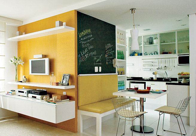 Cozinha integrada com sala e lousa para recados verde e amarelo